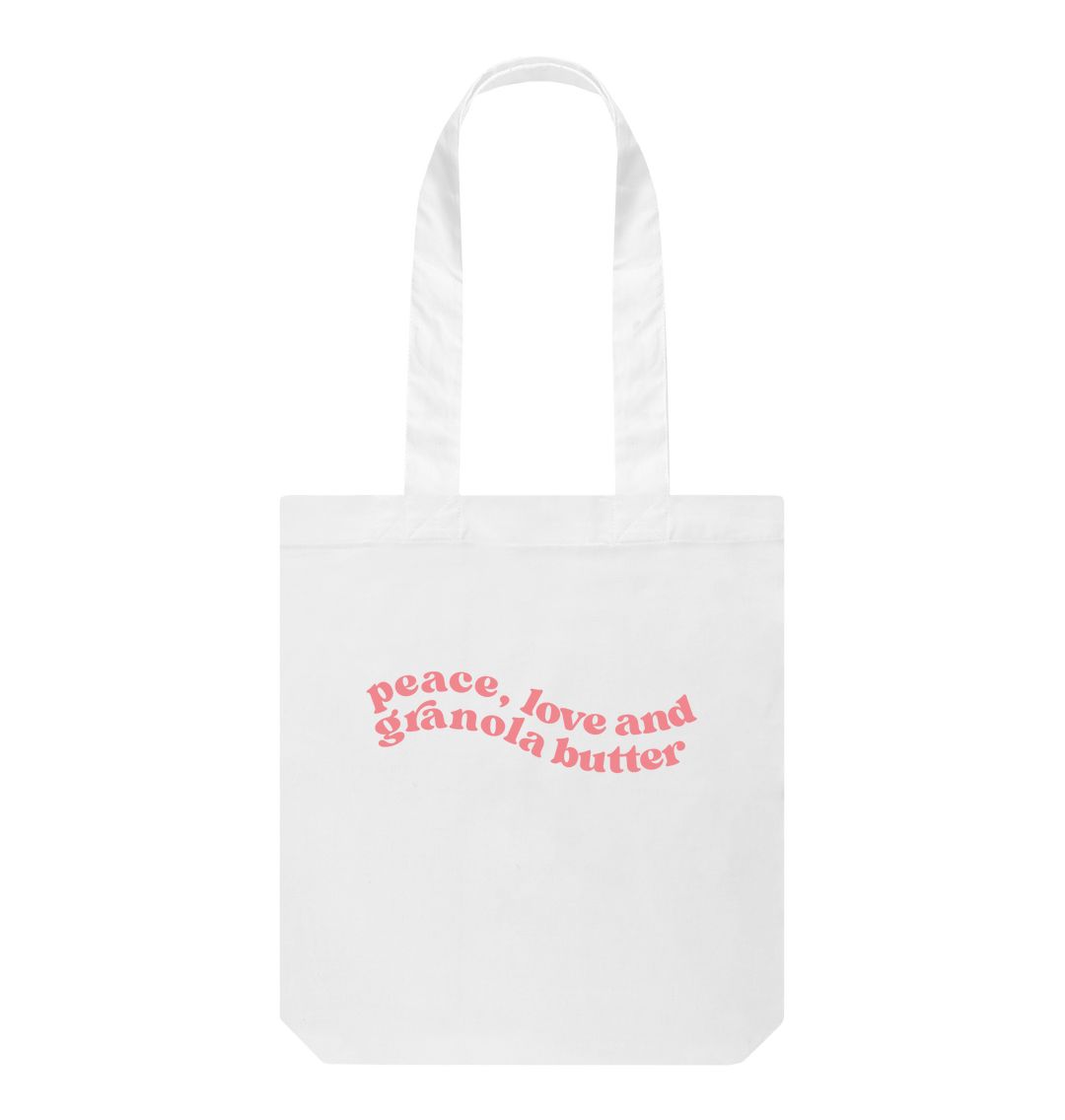 Our white tote bag with pink swirly font placed in the centre of the bag, our Granola butter merchandise  